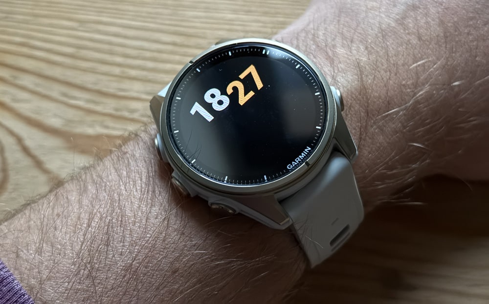 Hodinky Fenix 8 se zapnutým displejem na pánské ruce